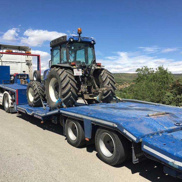 camión transportando tractor